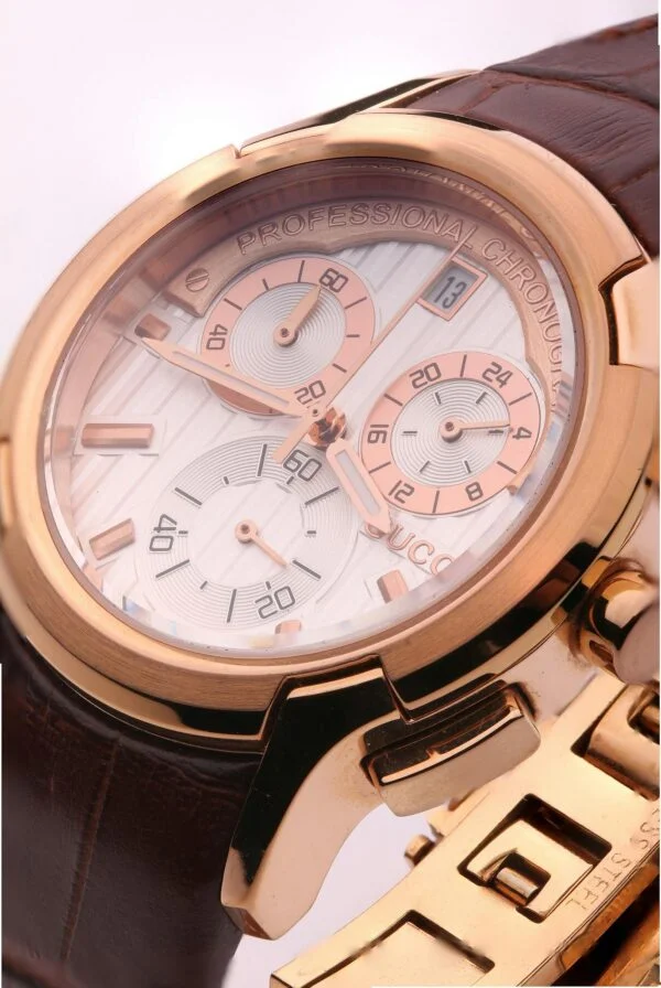 Detailed close-up of a luxurious gold chronograph watch with brown leather strap.